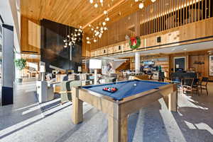 Rec room with a high ceiling, wood walls, billiards, and wooden ceiling
