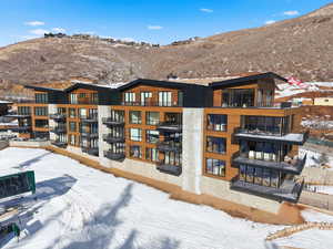 Snow covered building with a view of apartment building / complex and a mountain view
