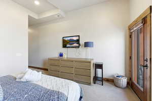 Carpeted bedroom with baseboards and access to outside