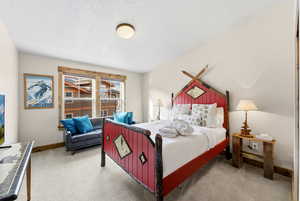 Bedroom with light carpet and a textured ceiling