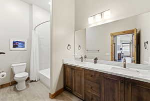 Full bath featuring double vanity and shower / bath combo with shower curtain