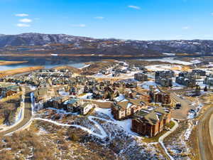 Aerial view of property and surrounding area with a water and mountain view and nearby suburban area