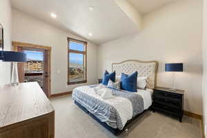 Bedroom with light colored carpet, vaulted ceiling, access to outside, and recessed lighting