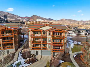 Drone / aerial view of a mountain backdrop and apartment complex / building