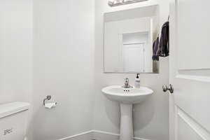 Bathroom featuring toilet and baseboards