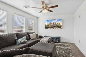 Living room with ceiling fan and baseboards