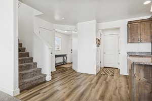 Unfurnished living room with stairs and dark wood-type flooring