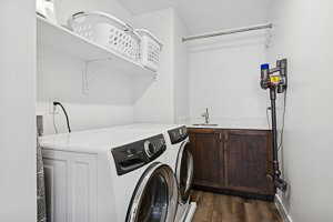Laundry area featuring washer and clothes dryer and dark wood-type flooring
