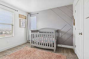 Carpeted bedroom featuring a nursery area and a closet