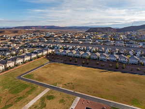 Aerial view of property and surrounding area featuring a mountainous background and nearby suburban area