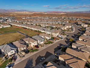 Aerial view of property and surrounding area featuring nearby suburban area and a mountain backdrop