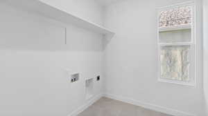 Washroom featuring electric dryer hookup, washer hookup, and light tile patterned flooring