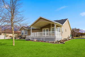 View of back of home with a deck and a shingled roof