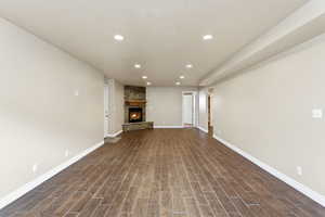 Unfurnished living room with wood finish floors, recessed lighting, and a fireplace