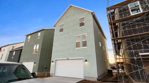 View of side of home featuring stucco siding, a garage, and driveway