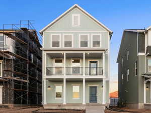 View of front of home featuring a balcony, board and batten siding, and covered porch