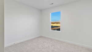 Carpeted empty room featuring baseboards