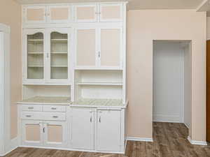 Unfurnished dining area featuring dark wood finished floors and baseboards