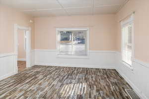 Family room featuring dark wood-style floors and a wainscoted wall