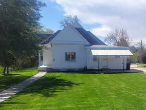 Bungalow-style house featuring a front yard and lengthy driveway with ample parking.