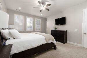 Bedroom featuring light carpet, ceiling fan, and recessed lighting