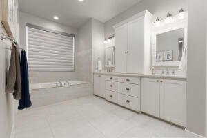 Bathroom featuring double vanity, a garden tub, recessed lighting, and light tile patterned flooring
