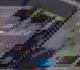 Aerial view of property and surrounding area with a pool area