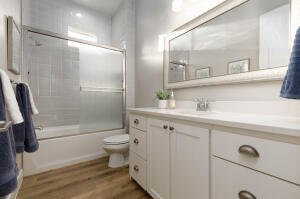 Full bathroom featuring vanity, shower / bath combination with glass door, and light wood-type flooring