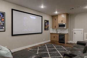 Home theater room with dark wood-type flooring and beverage cooler