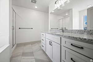 Bathroom with vanity, a shower stall, light marble finish floors, and recessed lighting