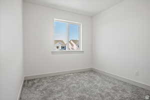 Carpeted spare room with baseboards
