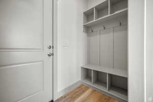 Mudroom featuring light wood finished floors and baseboards