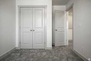 Unfurnished bedroom with dark carpet and a closet