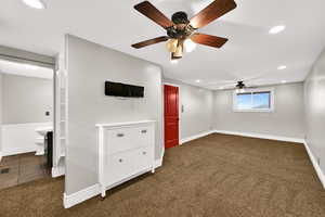 Unfurnished bedroom with recessed lighting, dark carpet, ceiling fan, and ensuite bathroom