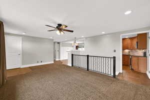 Unfurnished living room featuring light colored carpet, ceiling fan, recessed lighting, and light tile patterned floors