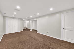 Finished basement featuring dark colored carpet and recessed lighting