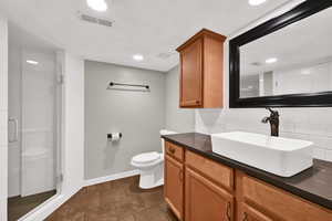 Bathroom with vanity, a shower stall, tasteful backsplash, and recessed lighting