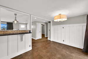 Kitchen with a wainscoted wall, a decorative wall, decorative light fixtures, tasteful backsplash, and recessed lighting