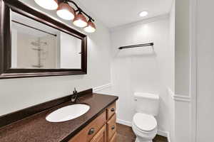 Full bath featuring vanity, a shower, and dark tile patterned flooring
