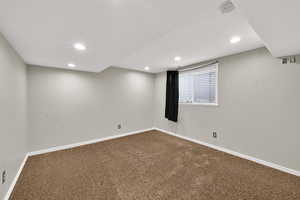 Carpeted empty room with baseboards and recessed lighting