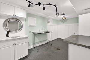 Miscellaneous room with wainscoting and a decorative wall