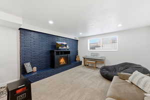 Living area featuring carpet floors, a lit fireplace, and recessed lighting