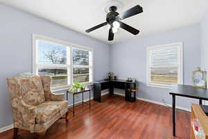 Living area featuring healthy amount of natural light, dark wood finished floors, and a desk