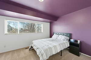 Bedroom featuring carpet and baseboards