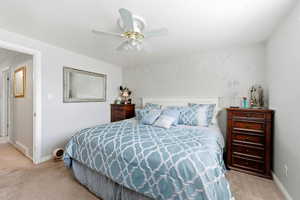 Bedroom with light colored carpet and a ceiling fan