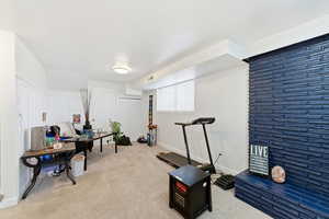 Exercise area featuring light carpet and baseboards