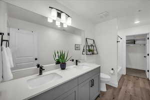Full bath with double vanity, shower / tub combo with curtain, ample lighting and walk in closet with owners closet.