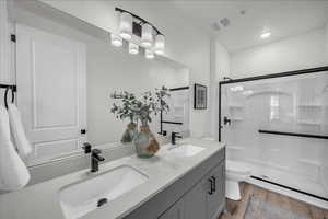 Full bath with double vanity, a shower stall for main level bedroom.