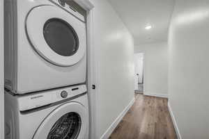 Laundry room featuring stacked washer and clothes dryer and recessed lighting.