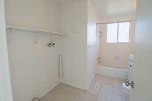 Bathroom featuring shower / washtub combination, vanity, and light tile patterned floors